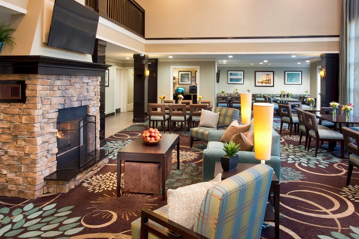 A warm and inviting interior featuring a seating area centered around a fireplace, with an adjacent dining space and decorative plants providing a homey touch. The space encourages socializing, unwinding, and enjoying shared moments, echoing the retreat qualities described in the section.