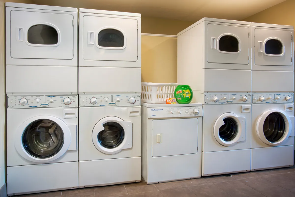A practical guest laundry facility with modern washers, dryers, and a laundry basket offers guests the convenience of keeping their clothes fresh during their stay.