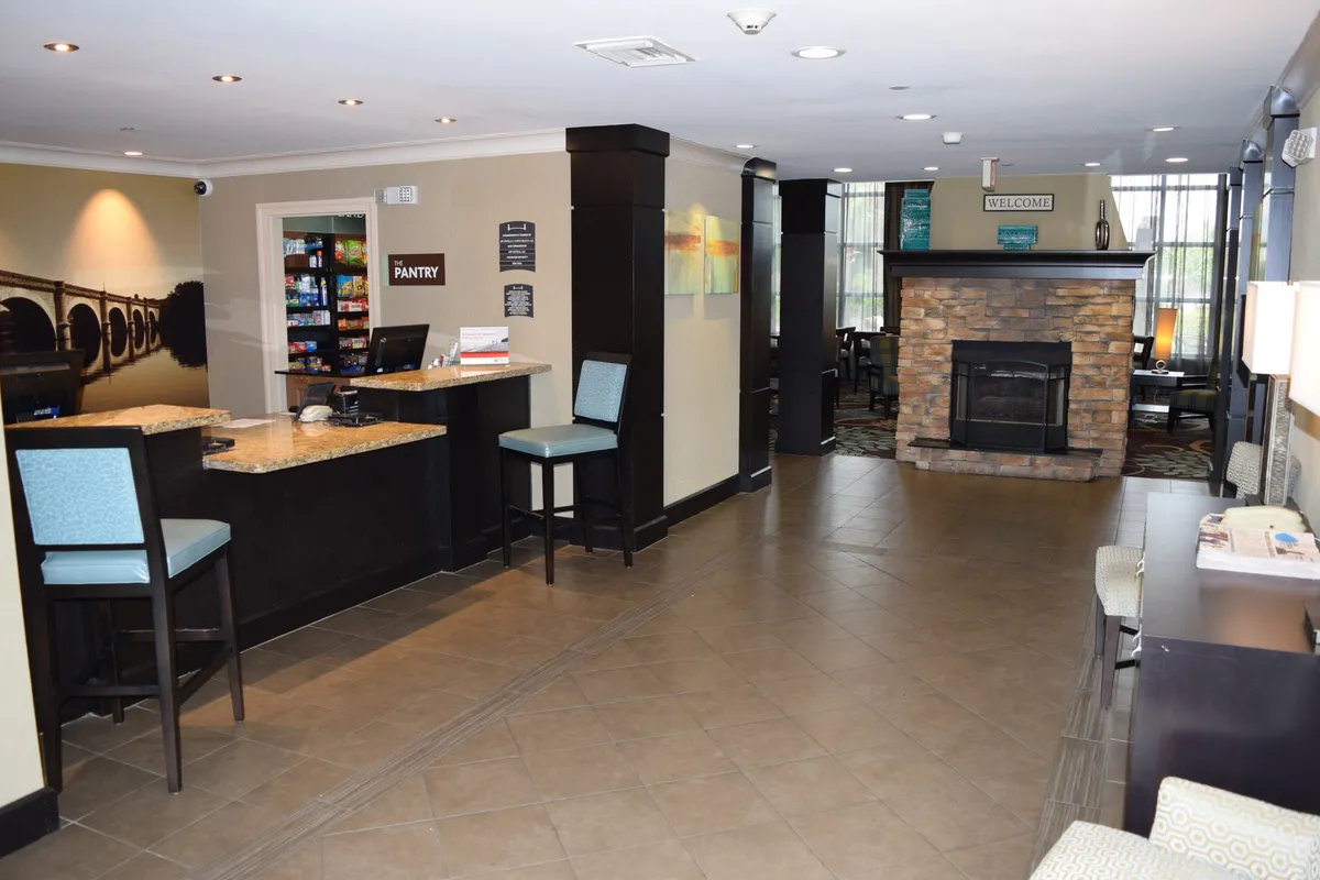 The interior front desk area is featured, complete with a stone fireplace, a well-kept pantry, and a welcoming seating zone. The setting highlights both guest service and communal areas, offering a glimpse of the property's hospitality and convenience.